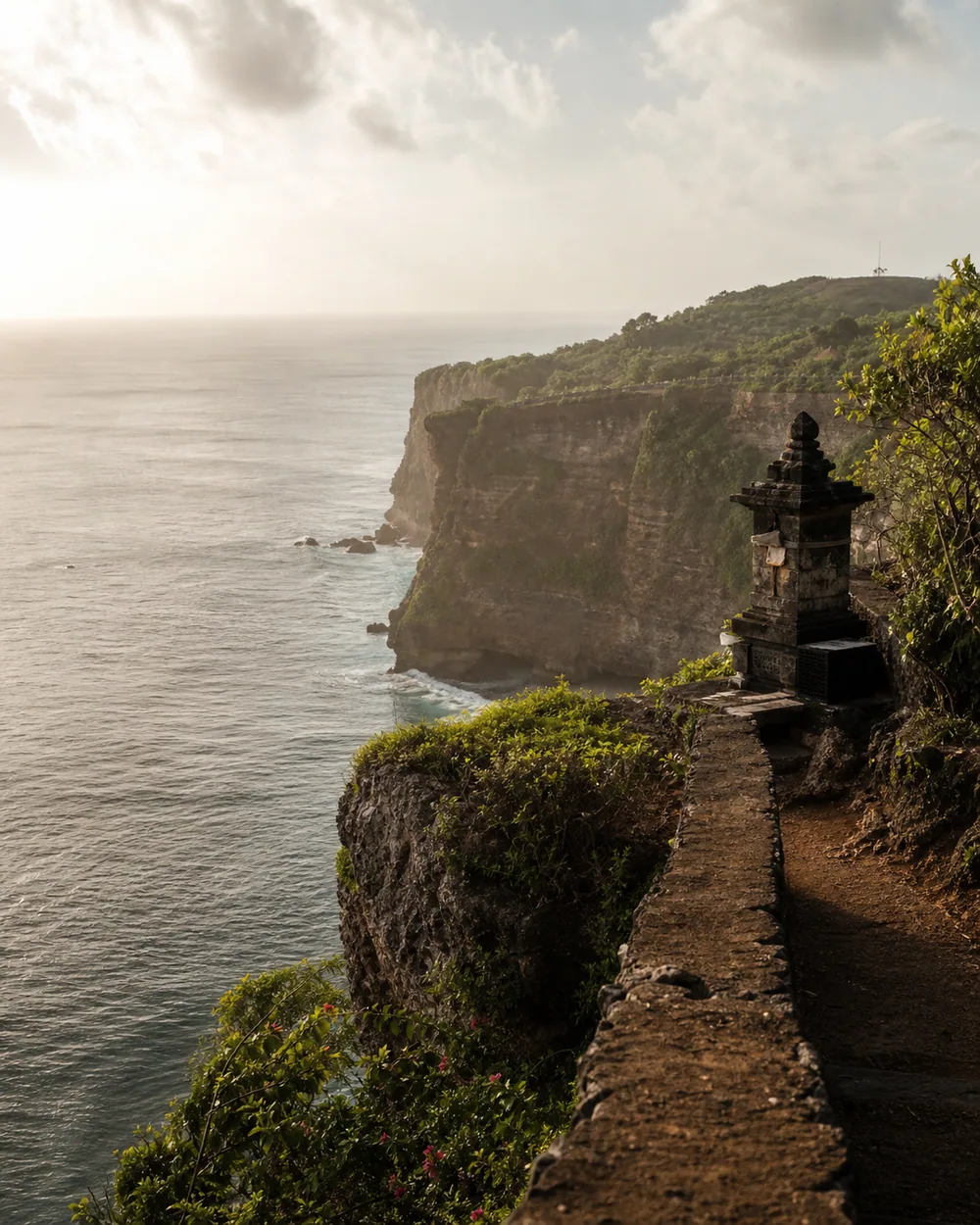 Uluwatu Temple perched on cliff above Indian Ocean at sunset